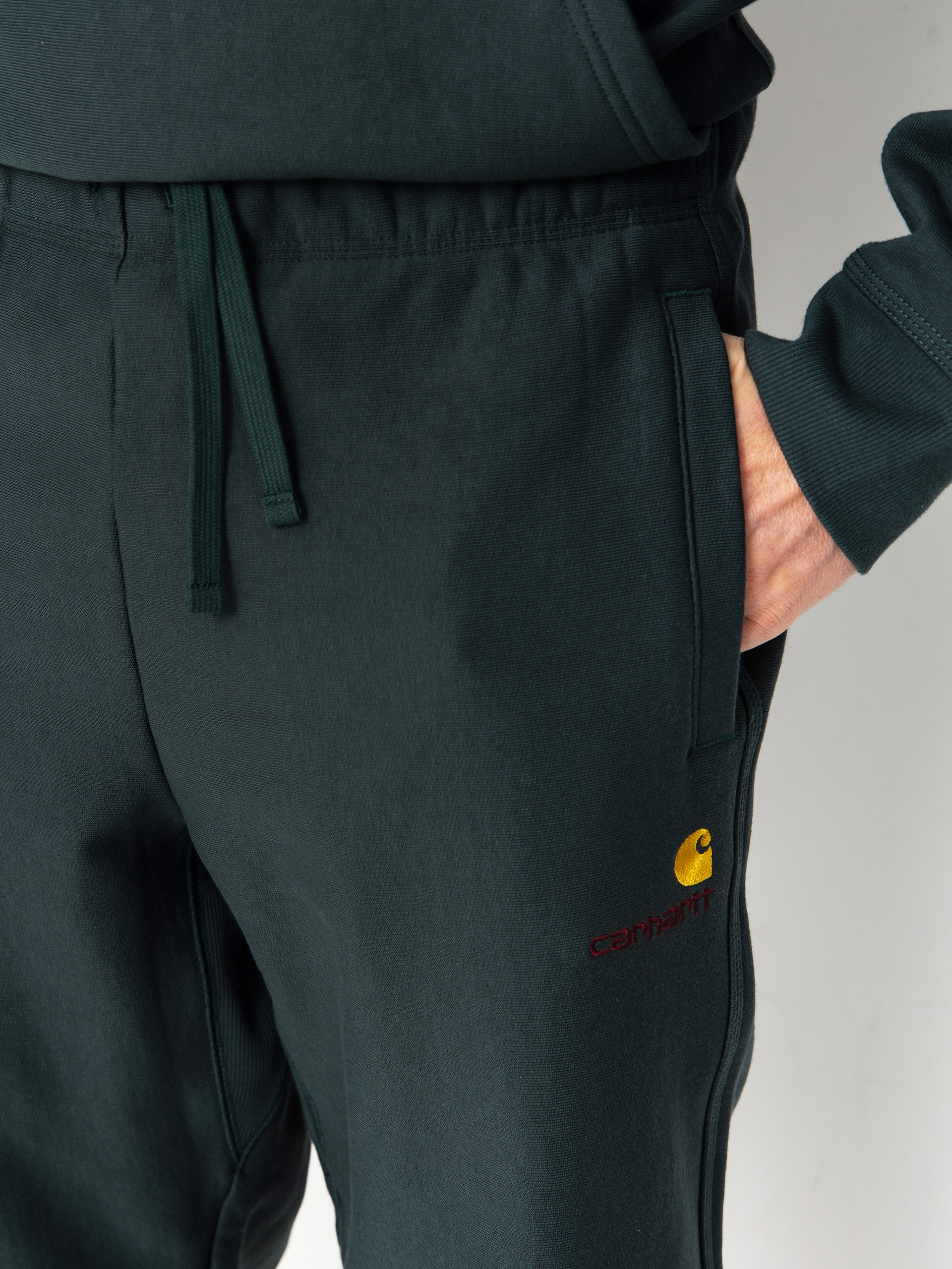 Штани Carhartt WIP American Script Jogging (kale green)